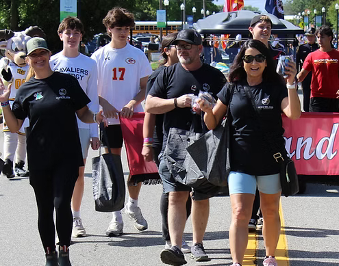 people walking at the front of the goochland day banner at the beginning o the goochland day parade.